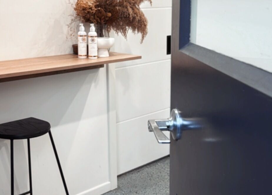 Open door to GlowbyBeca in Wilton, New South Wales. Minimalist salon interior with simple decor.