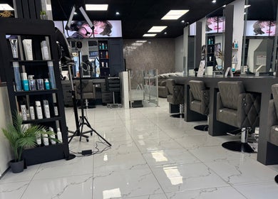 Modern interior of Alaan Williams Hair Experts, Pontypridd, Wales, GB featuring plush chairs and sleek design.