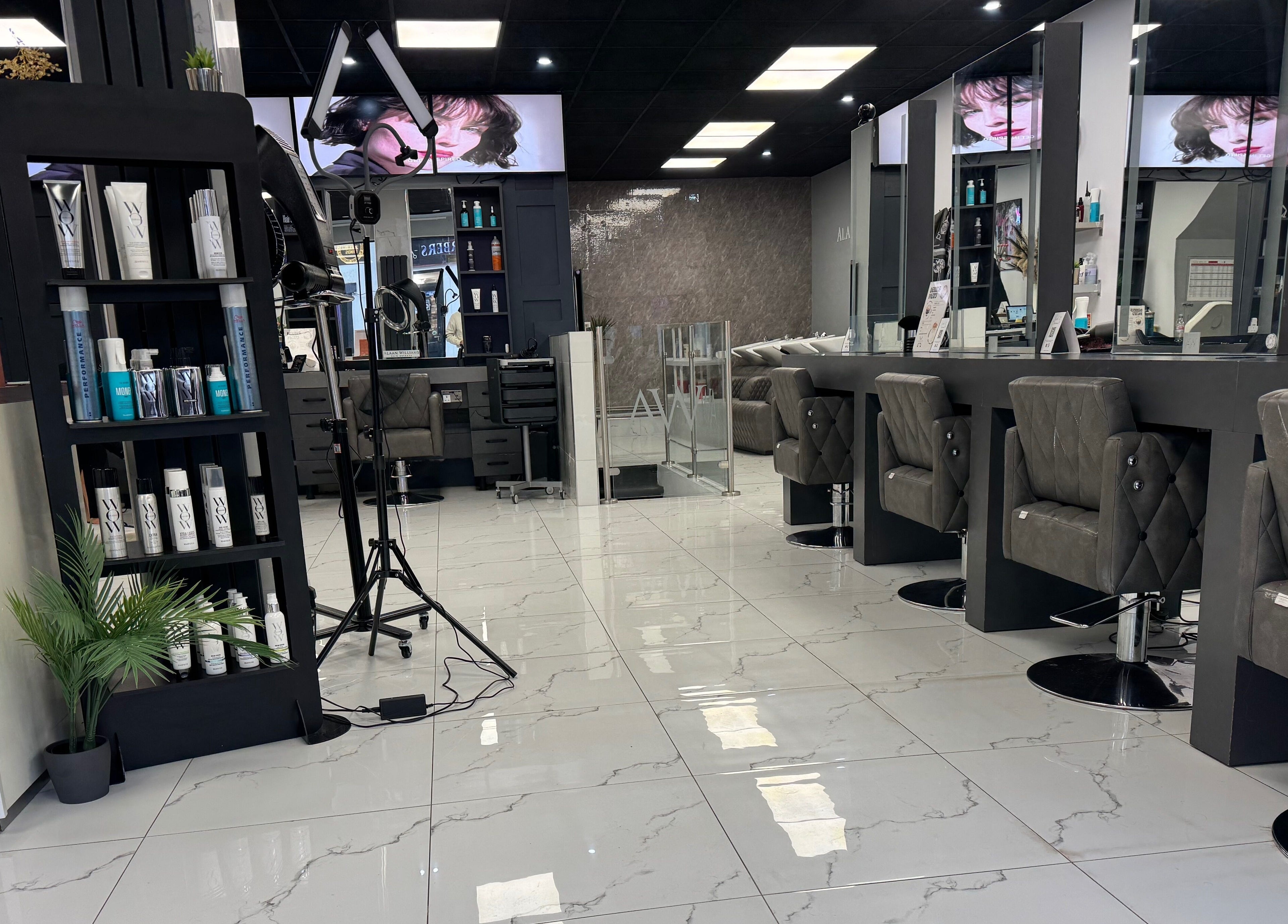 Modern interior of Alaan Williams Hair Experts, Pontypridd, Wales, GB featuring plush chairs and sleek design.
