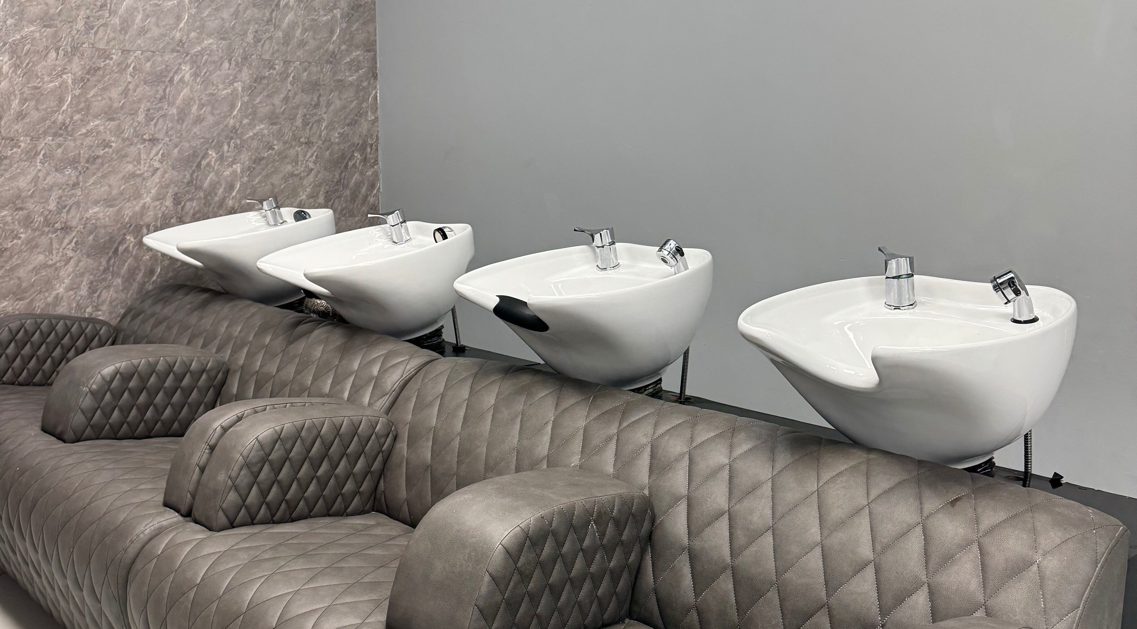 Luxurious wash station at Alaan Williams Hair Experts, Pontypridd, Wales, GB, showcasing quilted seating.