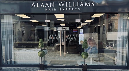 Front view of Alaan Williams Hair Experts in Pontypridd, Wales, GB with stylish signage and greenery.