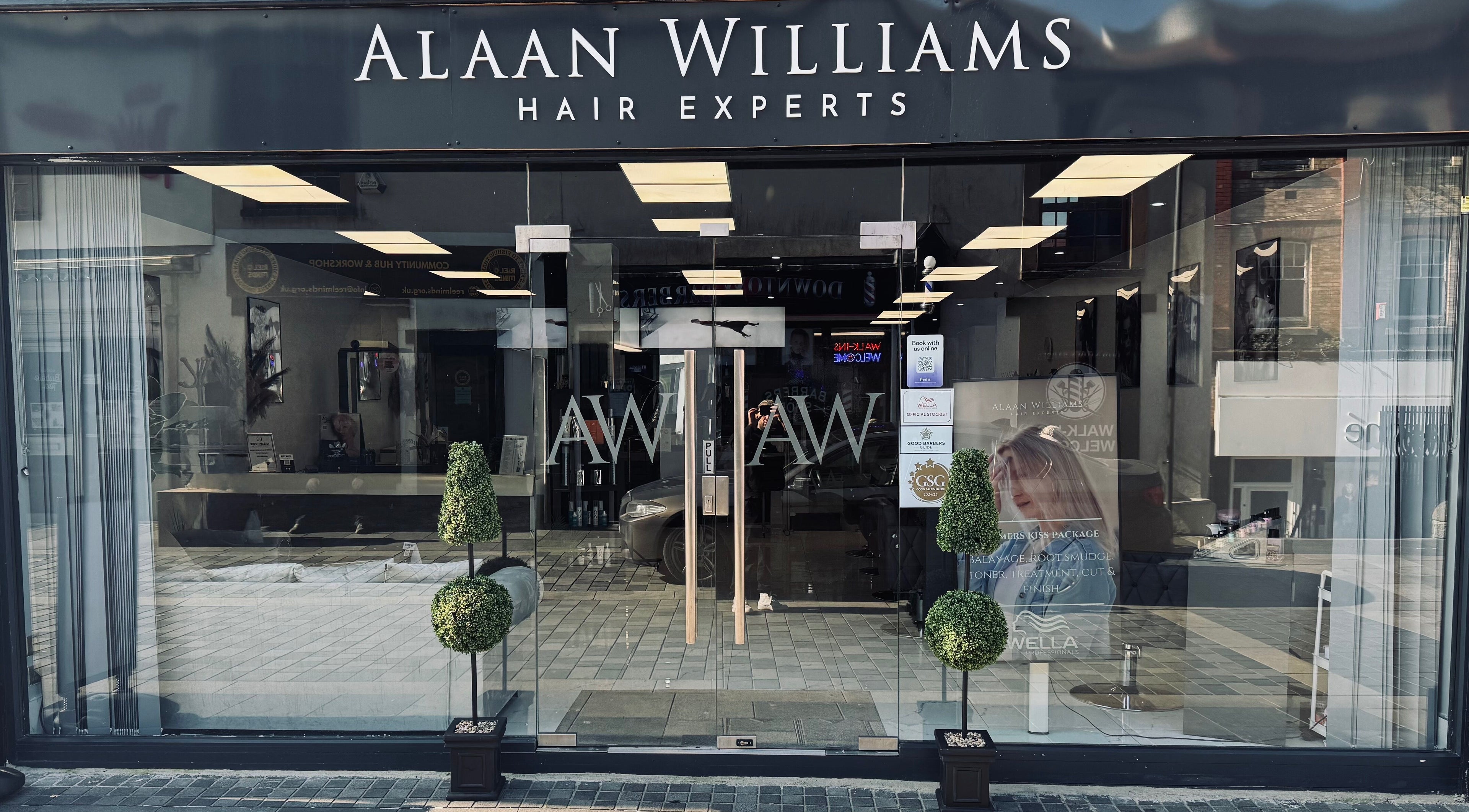 Front view of Alaan Williams Hair Experts in Pontypridd, Wales, GB with stylish signage and greenery.