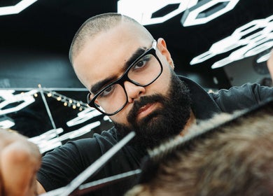 Barber at Frankston Barbers in Melbourne, Victoria, AU, focuses on a client's haircut under modern lighting.