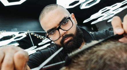 Barber at Frankston Barbers in Melbourne, Victoria, AU, focuses on a client's haircut under modern lighting.