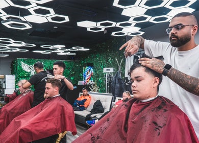 Barber at Frankston Barbers in Melbourne, Victoria, AU, giving a stylish haircut under modern lighting.