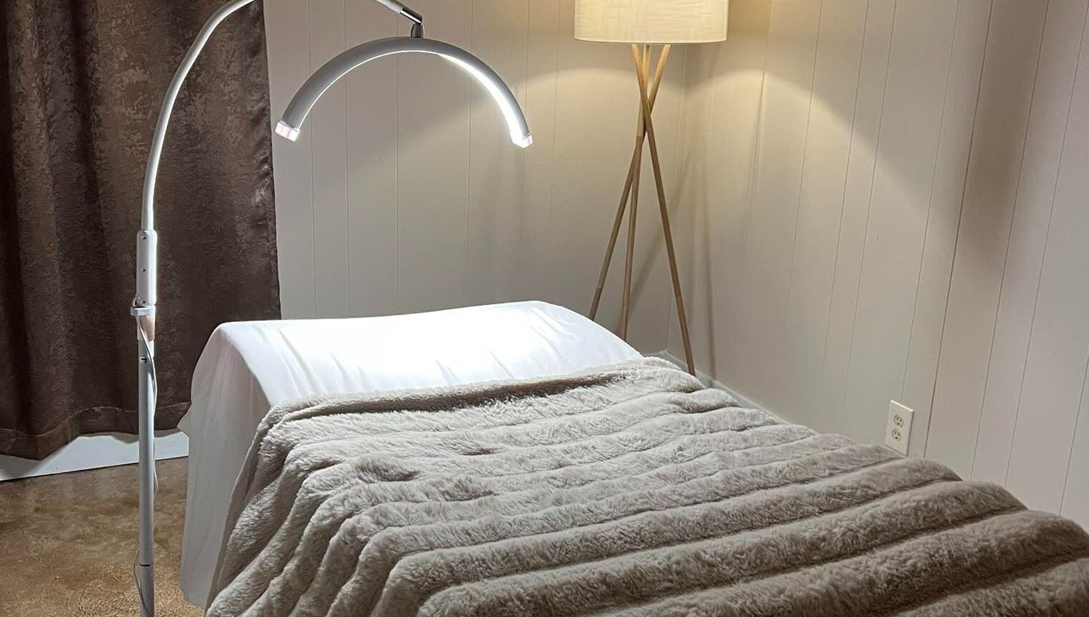 Comfortable treatment bed in Leigh Mac, Opelika, Alabama, US with soft lighting and plush blanket.