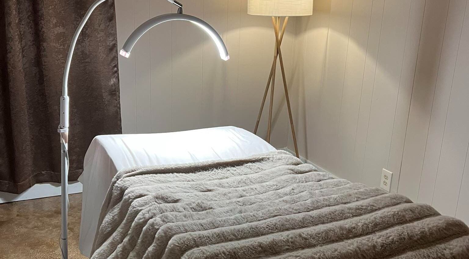 Comfortable treatment bed in Leigh Mac, Opelika, Alabama, US with soft lighting and plush blanket.