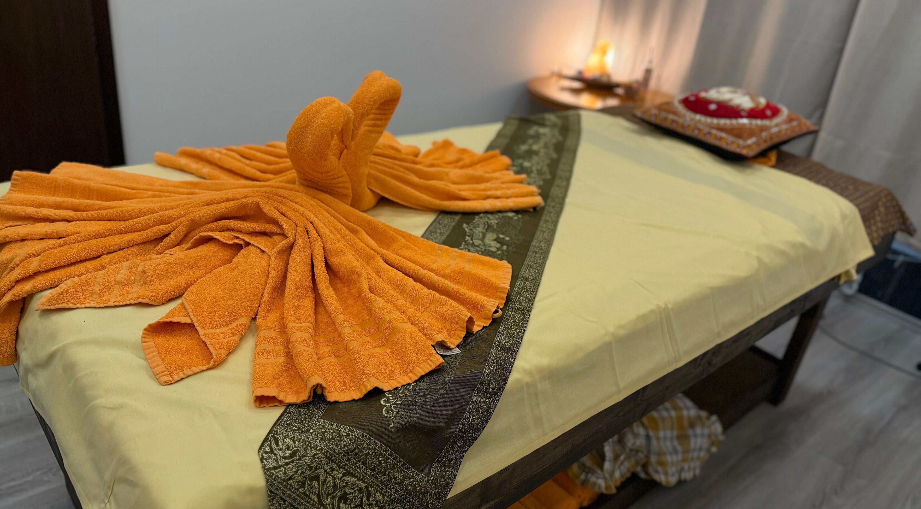Massage table with elegant orange towel art arrangement at Jungmannova 742/22, Praha 1, Hlavní město Praha, CZ.