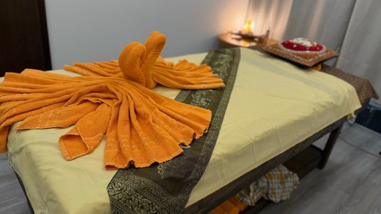 Massage table with elegant orange towel art arrangement at Jungmannova 742/22, Praha 1, Hlavní město Praha, CZ.