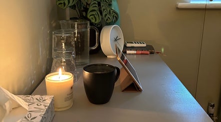 A cozy wellness corner at Alex Hammond Knowles in Berkhamsted, England, GB with candle and clock.