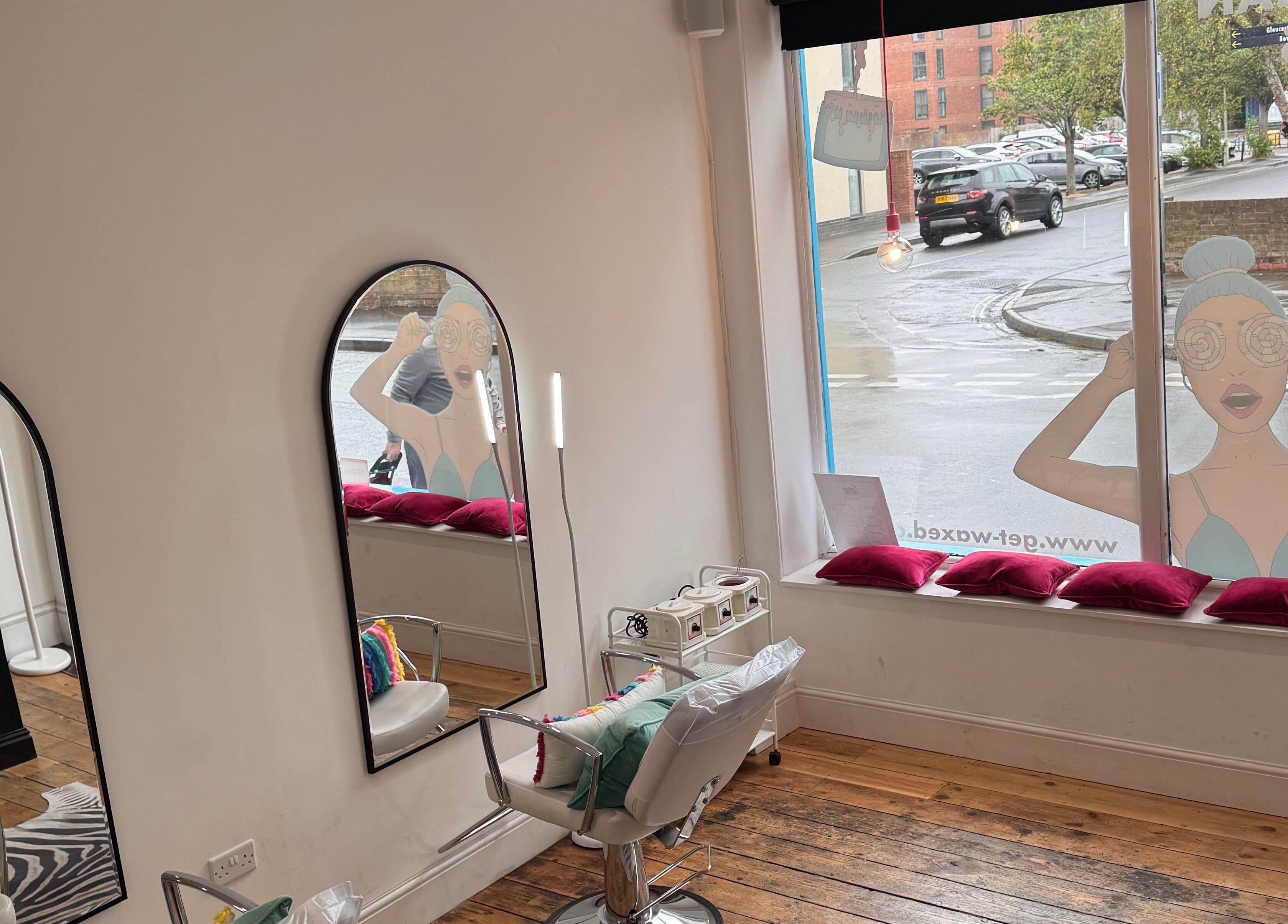 Interior view of Get Waxed, Gloucester, England, showing salon chairs and mirrors.