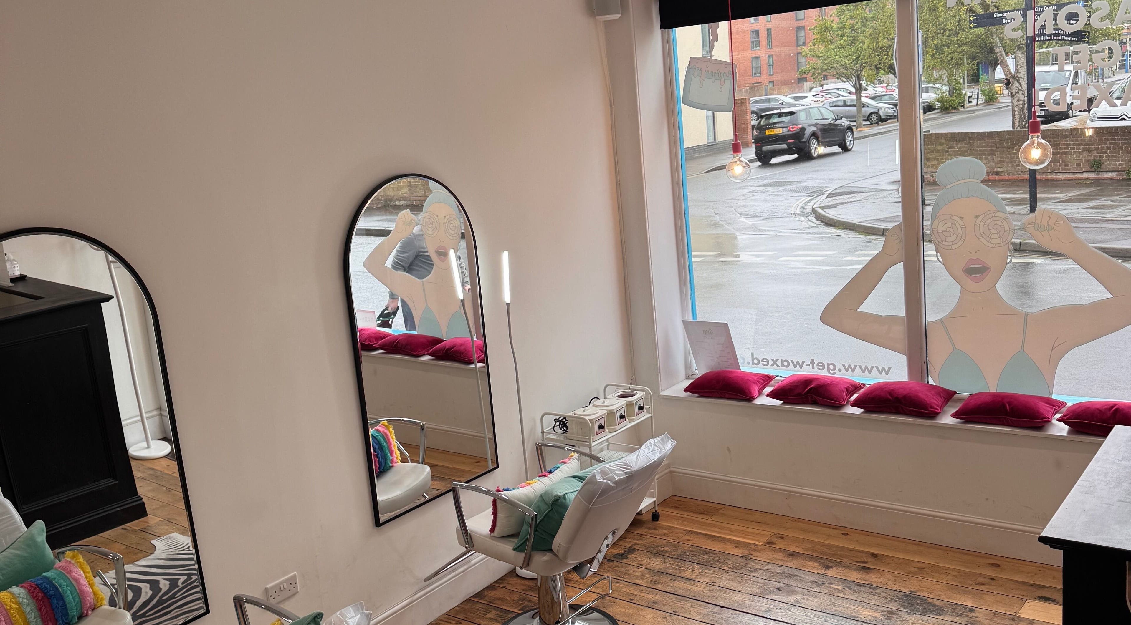 Interior view of Get Waxed, Gloucester, England, showing salon chairs and mirrors.