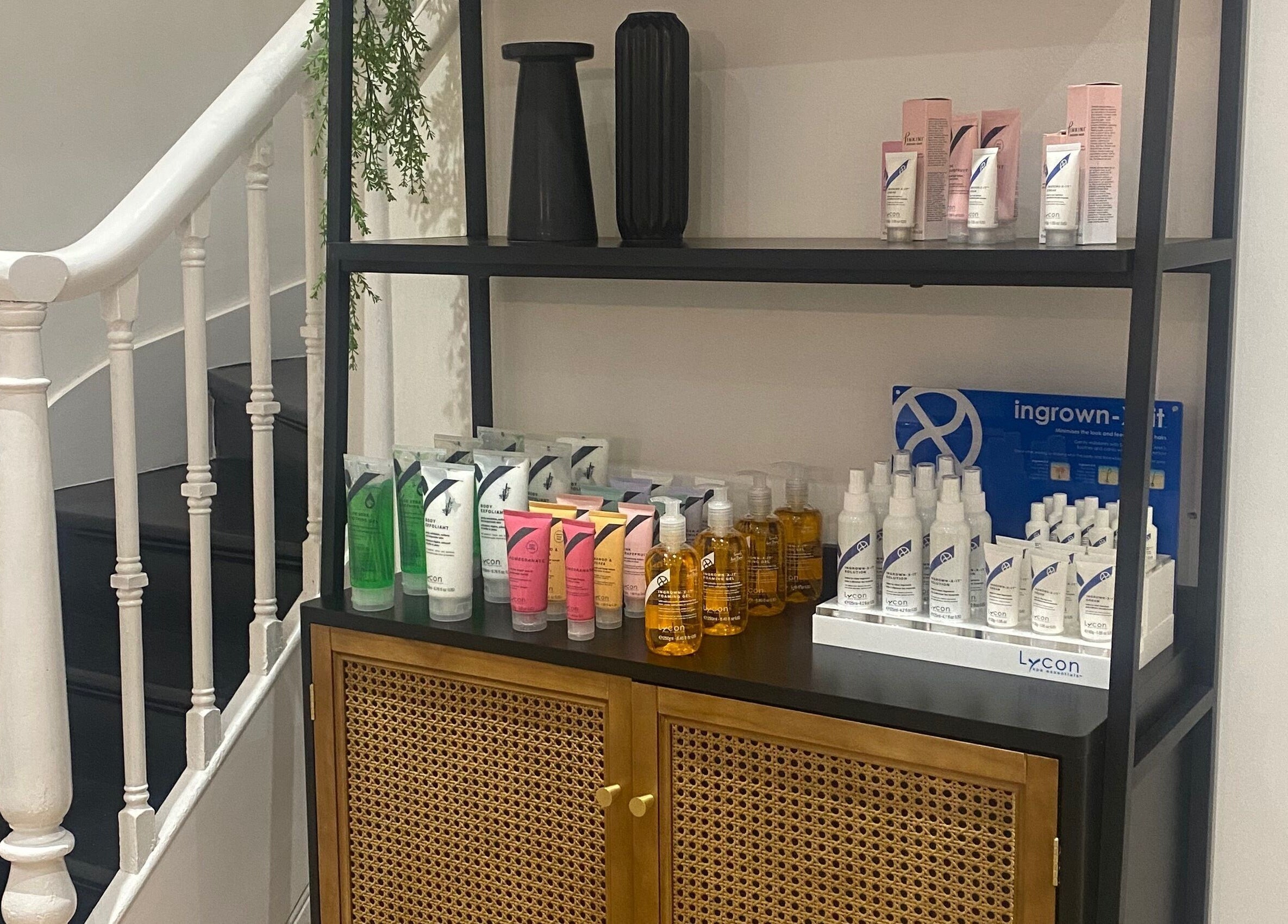 Elegant display of beauty products at Get Waxed, Gloucester, England, GB, adding charm to staircase corner.