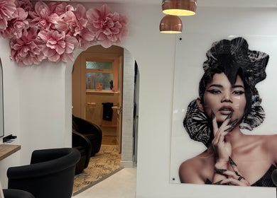 Stylish interior of Shelley Lane Salon in Aberkenfig, Wales, GB, with pink floral décor and chic portrait art.