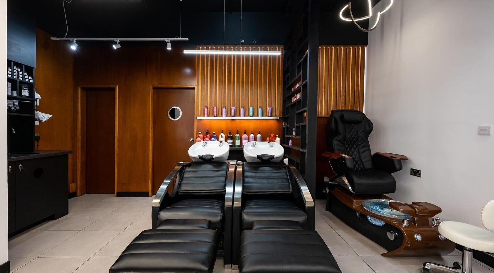 Modern hair washing stations at Kapil Hair Studio, Harrow, England. Luxurious spa ambiance with sleek seating.