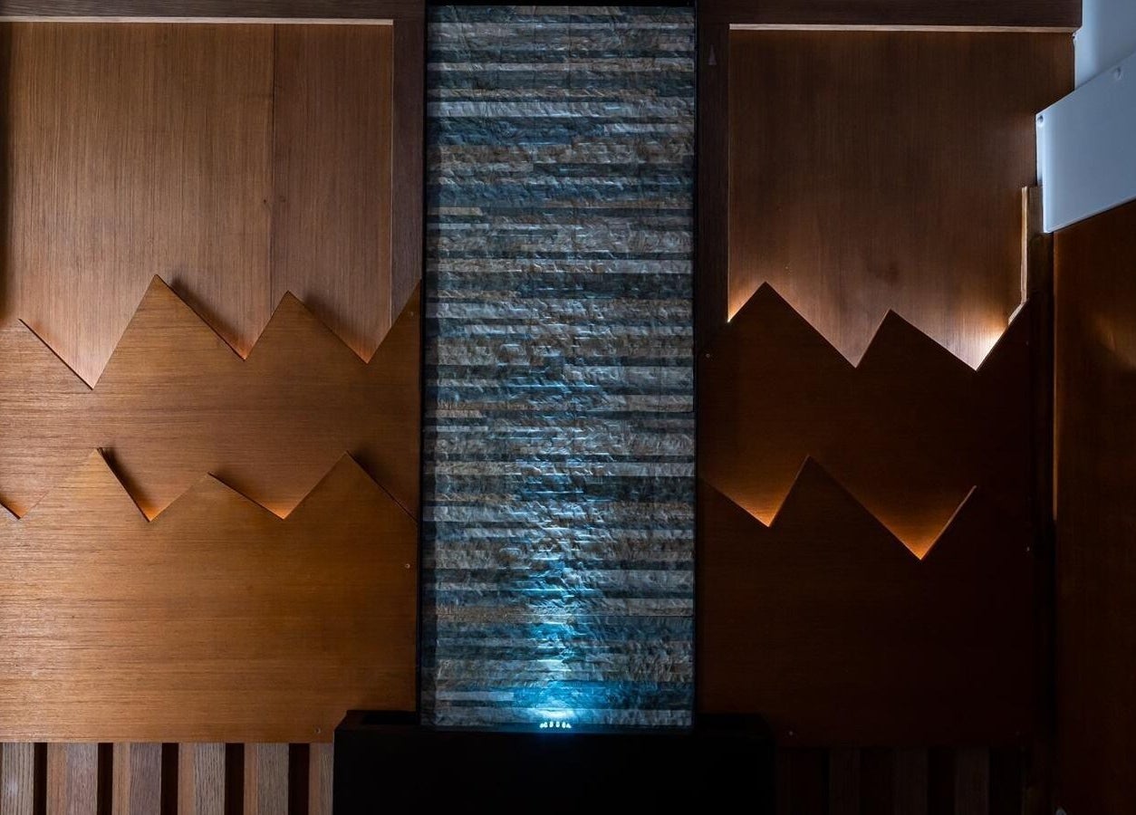 Kapil Hair Studio interior wood and stone decor in Harrow, England, GB showcasing rustic elegance.