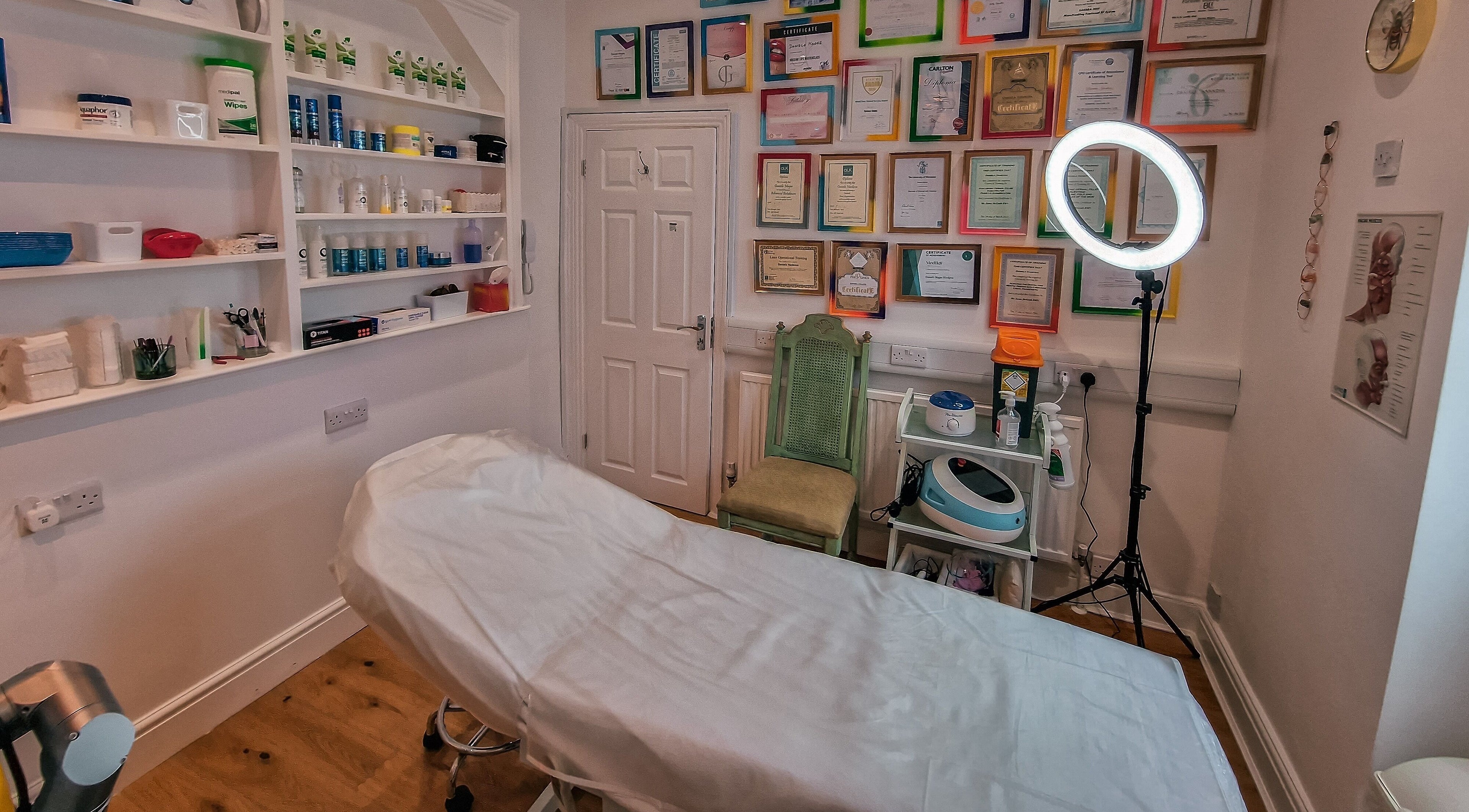Professional treatment room at Forever Clinic, Cheltenham, England, GB, showcasing certificates and equipment.
