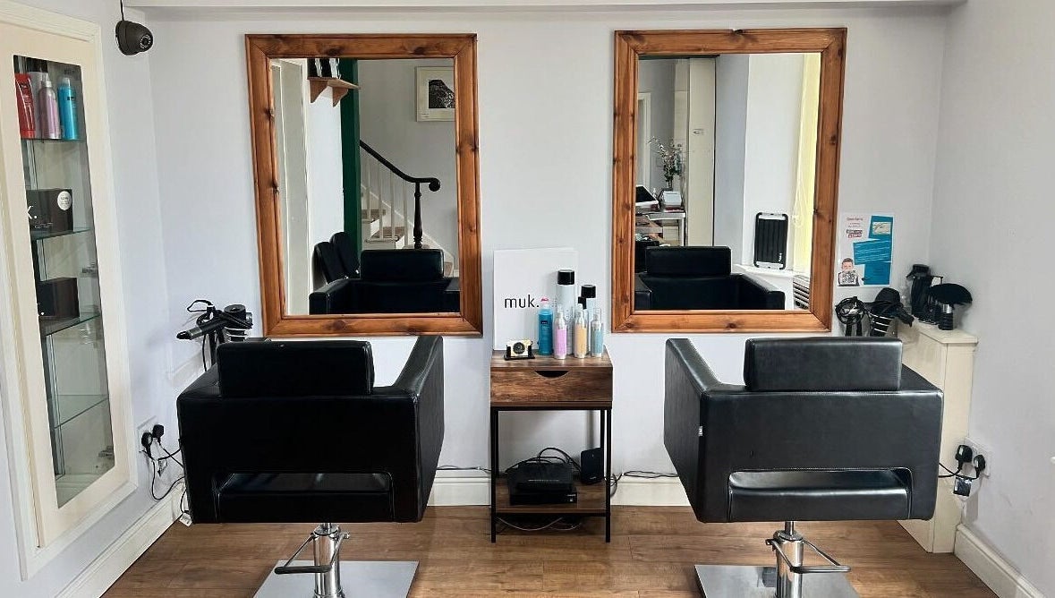 Interior of David Charles Hair, Health and Beauty Studio in Raunds, England, featuring stylish salon chairs and mirrors.