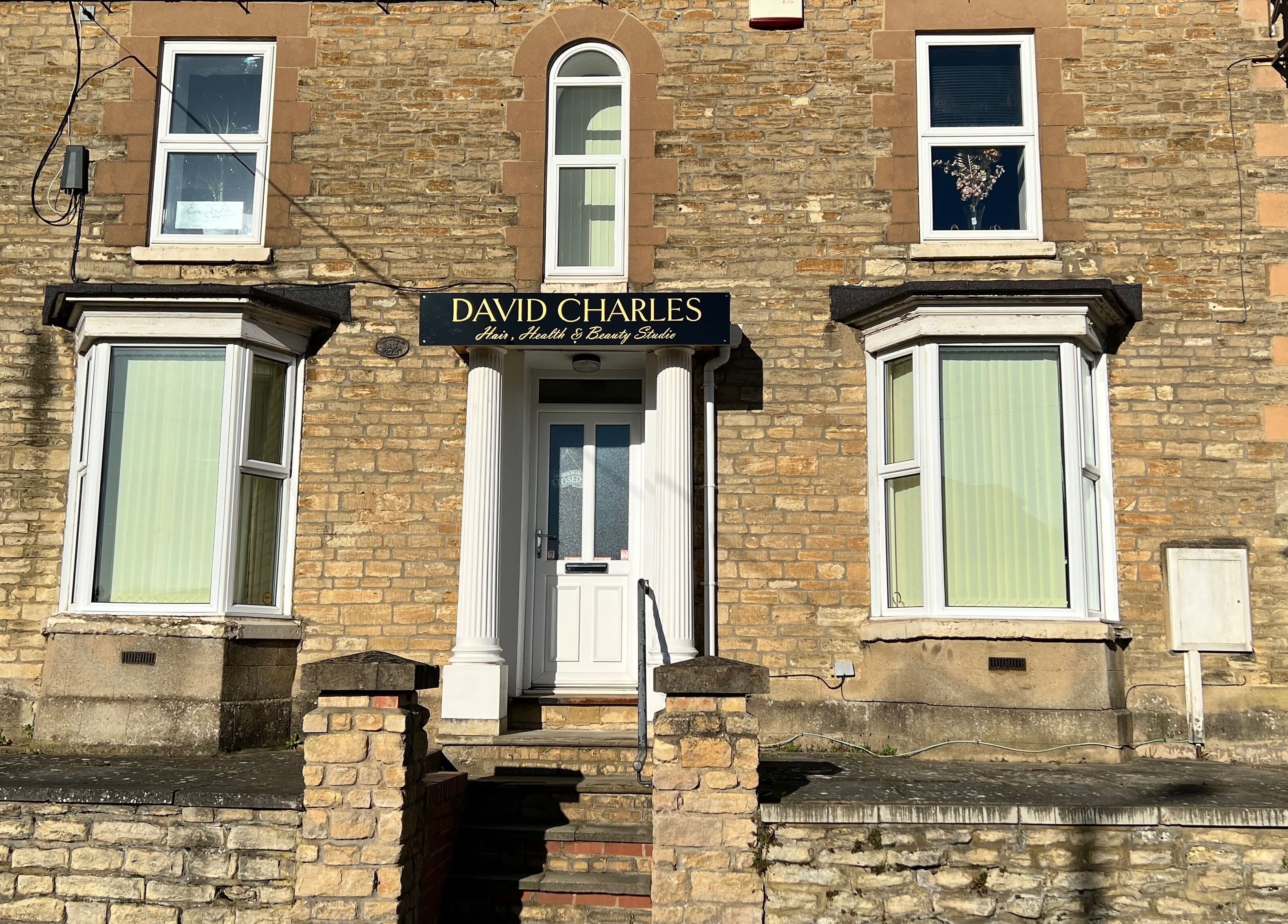 Front of David Charles Hair, Health and Beauty Studio in Raunds, England, GB showcasing a stone facade.