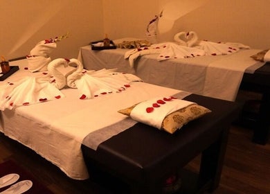 Elegant couple's massage setup at Body Raaga Wellness Spa - Jp Nagar, Bengaluru, Karnataka, IN, with towel art and petals.