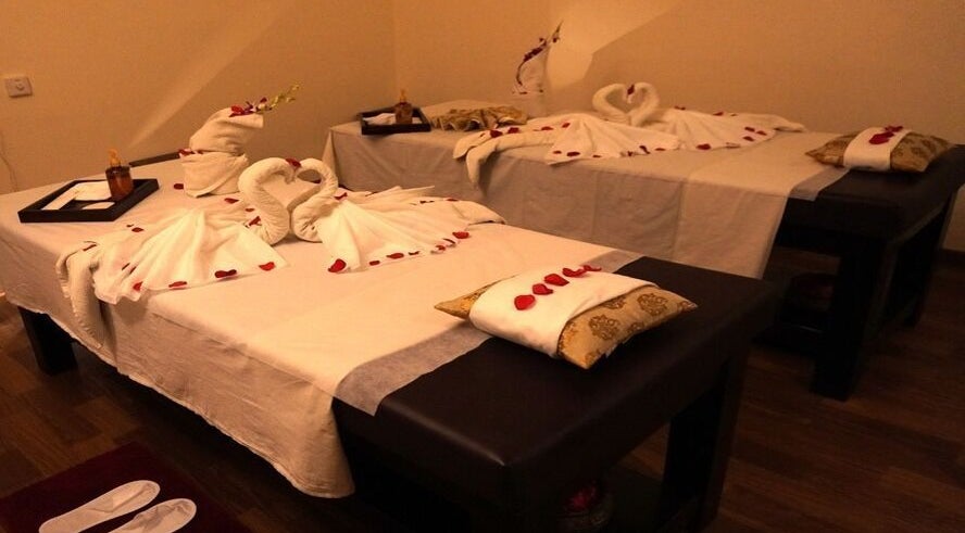 Elegant couple's massage setup at Body Raaga Wellness Spa - Jp Nagar, Bengaluru, Karnataka, IN, with towel art and petals.