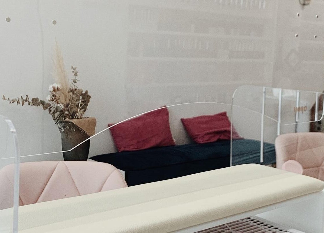 Modern manicure station at Milly and Jin, Hove, England, GB, with pink seating and decorative vase.