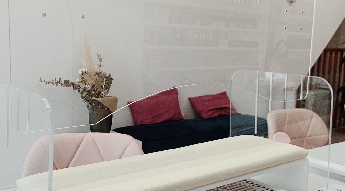 Modern manicure station at Milly and Jin, Hove, England, GB, with pink seating and decorative vase.