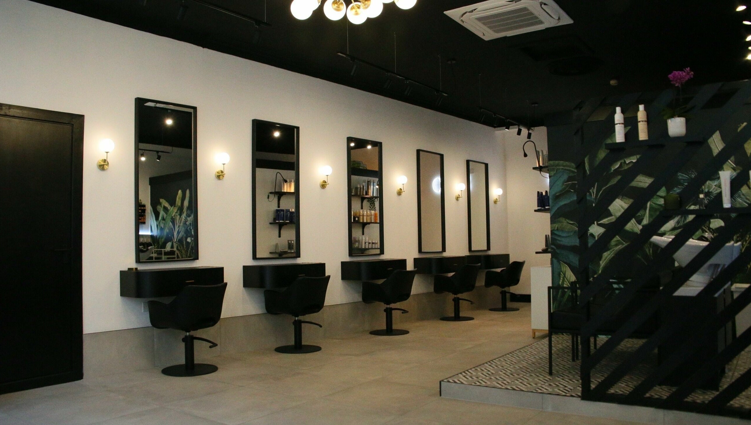 Modern salon interior at Simpson and Co, Stirling, Scotland, GB, featuring sleek chairs and mirrors.