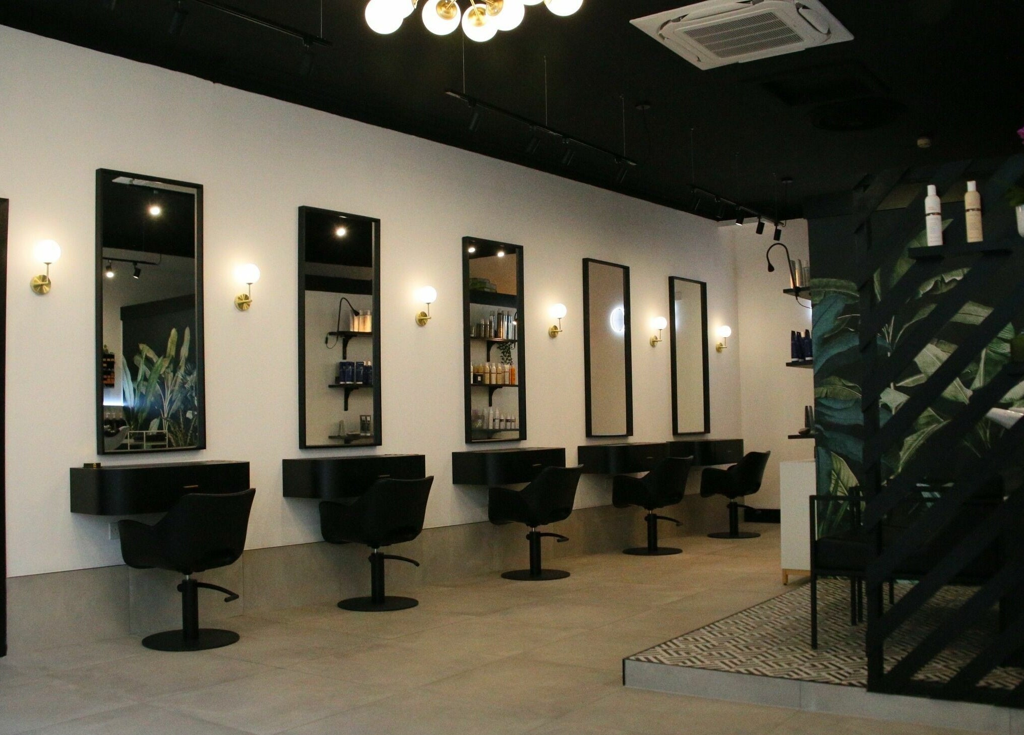 Modern salon interior at Simpson and Co, Stirling, Scotland, GB, featuring sleek chairs and mirrors.