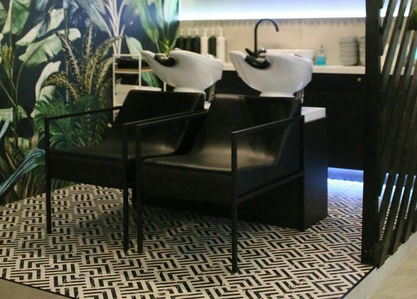 Modern shampoo chairs at Simpson and Co. in Stirling, Scotland, GB, with green foliage backdrop.