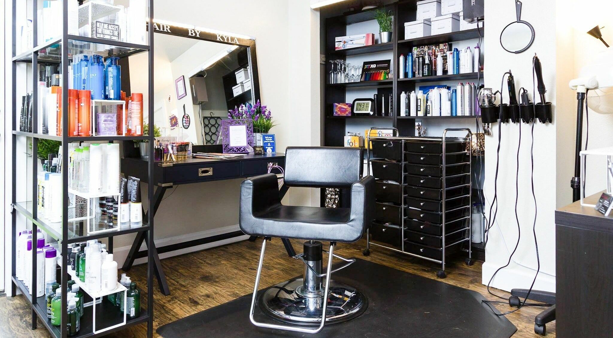 Stylish salon interior at Hair By Kyla, Vancouver, Washington, US, featuring a sleek chair and product shelves.