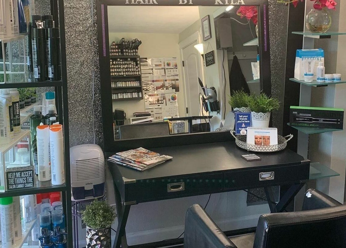 Elegant styling station at Hair By Kyla, Vancouver, Washington, featuring products and greenery decor.