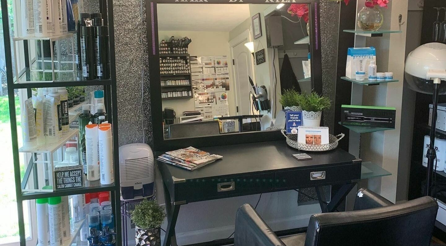 Elegant styling station at Hair By Kyla, Vancouver, Washington, featuring products and greenery decor.