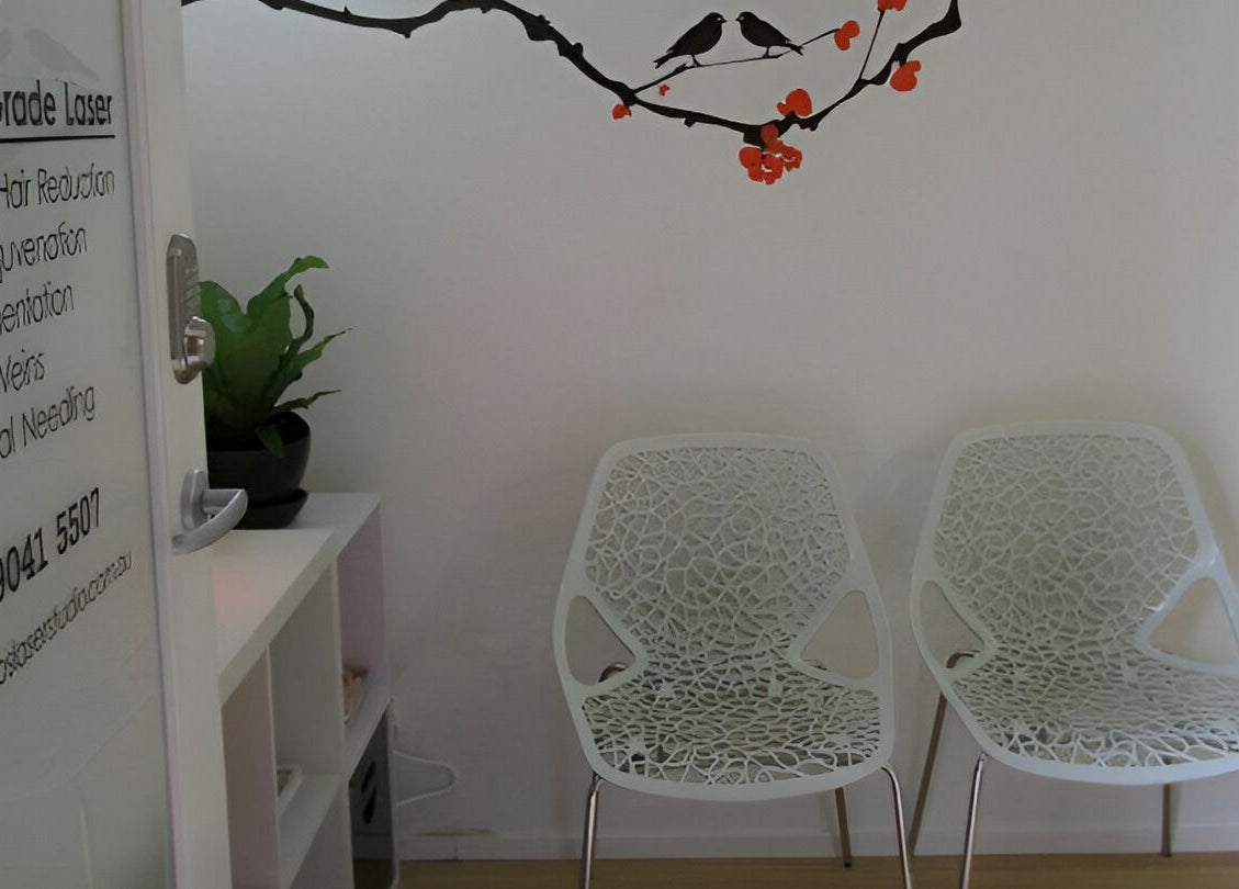 Modern waiting area at Helios Laser Studio in Melbourne, Victoria, AU with stylish chairs and laser service details.