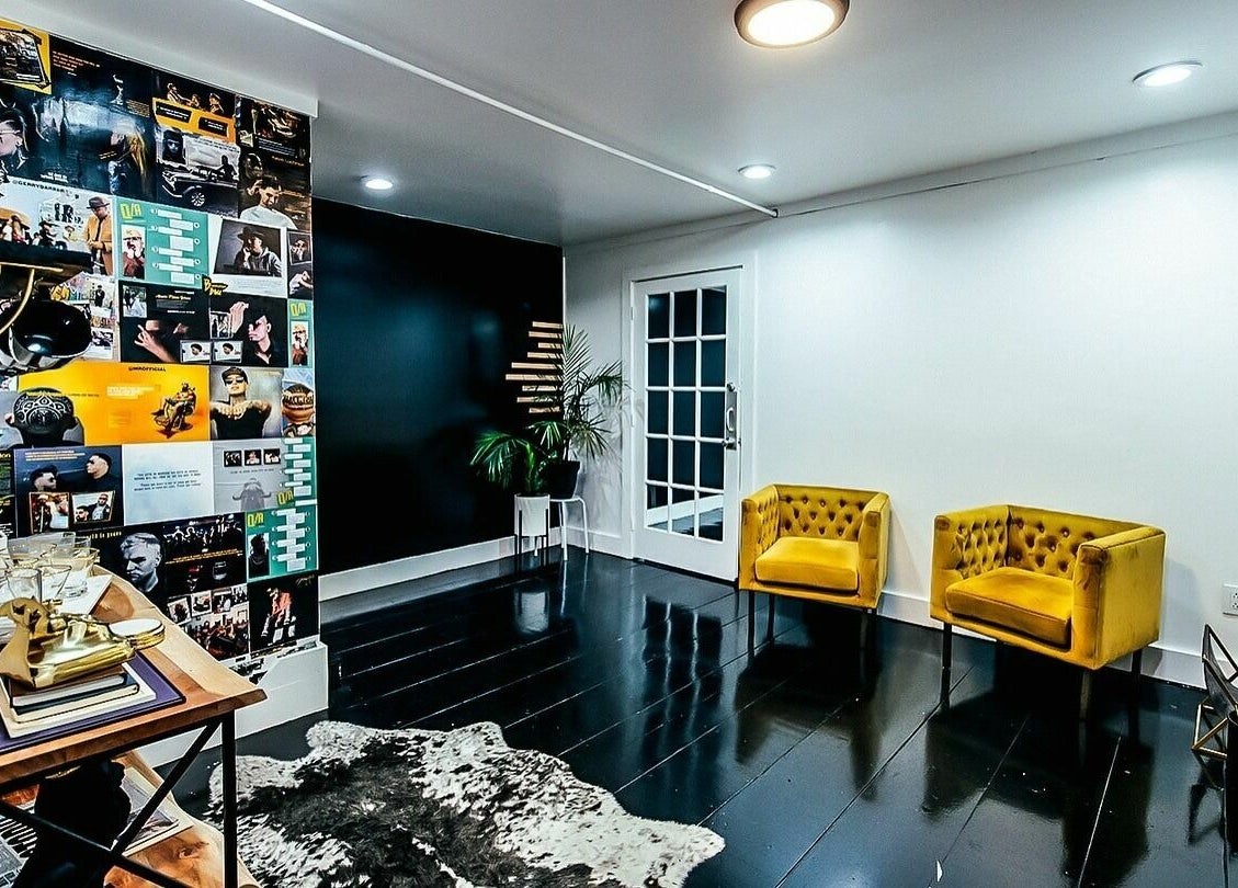 Stylish interior of B | K L A S S Y Barber Studio in Kansas City with yellow chairs and collage wall.