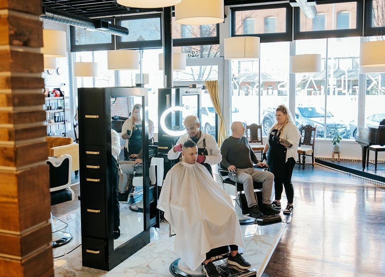 Stylish interior of B | K L A S S Y Barber Studio in Kansas City, Missouri, US with clients and stylists.