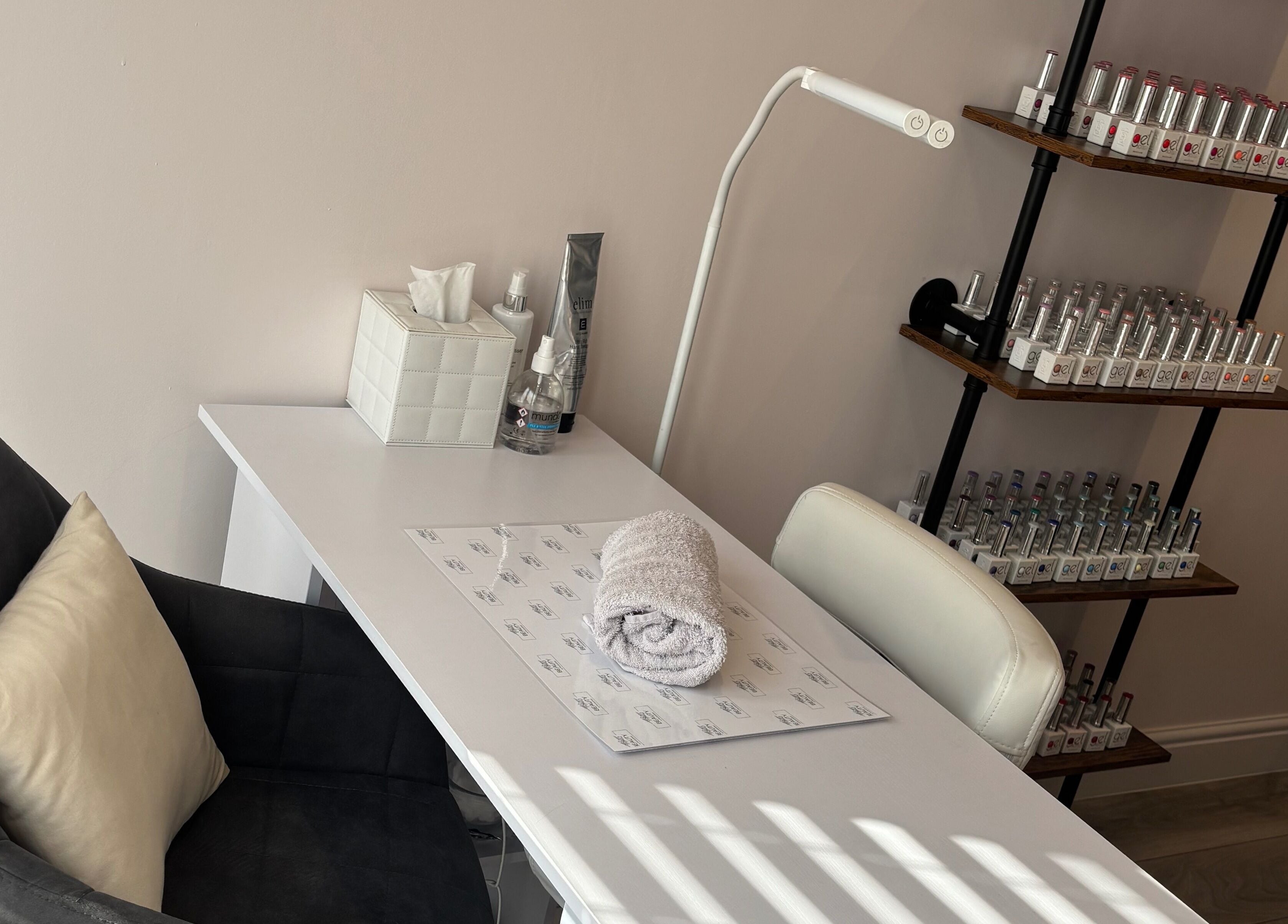 Cozy nail station at Beauty at The CowShed, Uttoxeter, England, GB showcasing polish collection and towel.