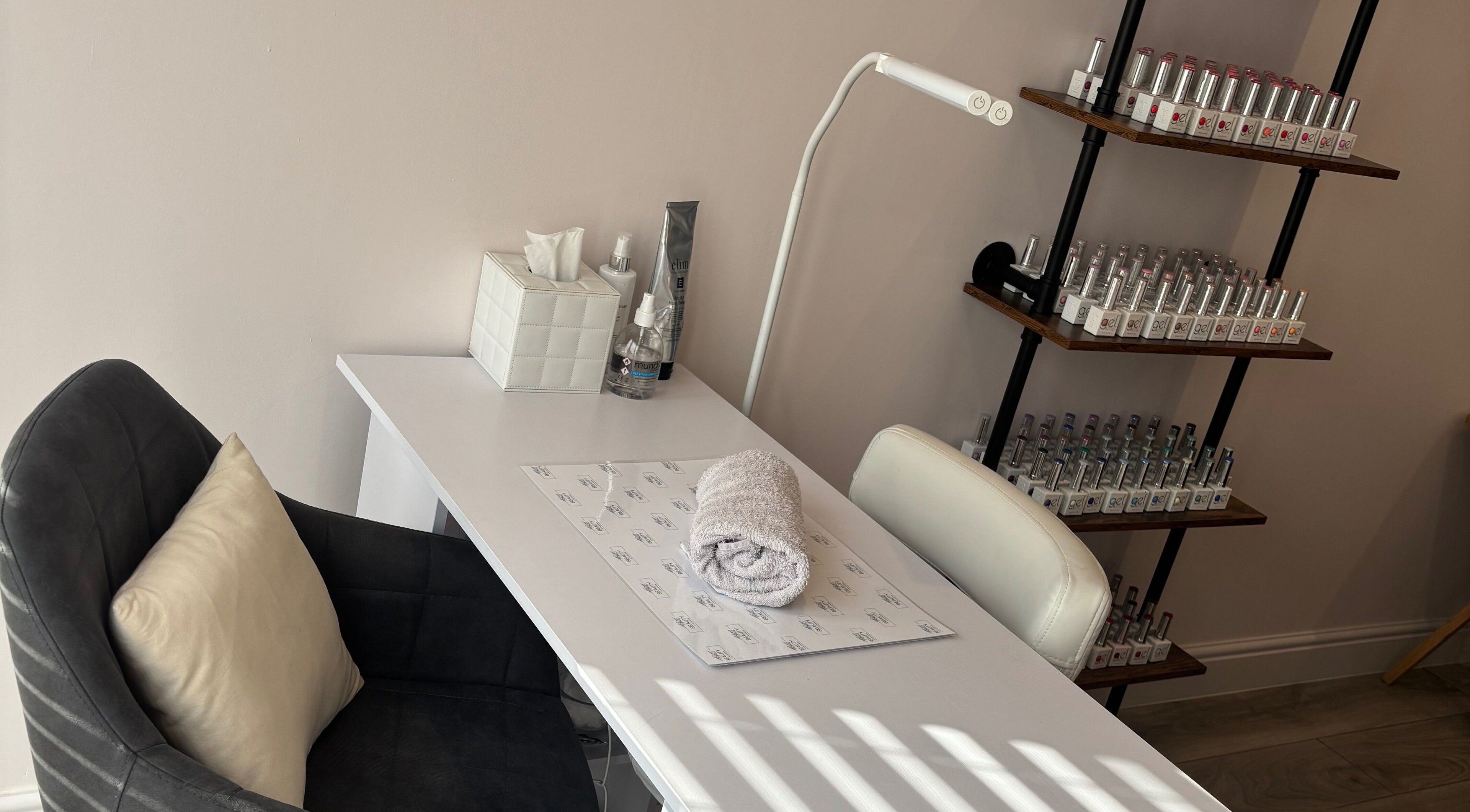 Cozy nail station at Beauty at The CowShed, Uttoxeter, England, GB showcasing polish collection and towel.