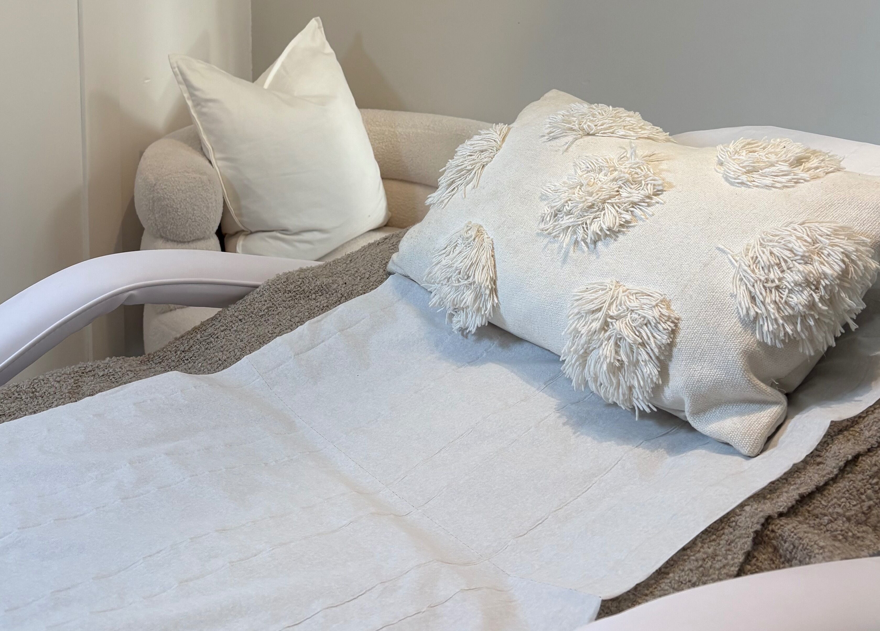 Relaxing treatment room at Mark One Beauty, Exeter, England, GB with plush pillows on a comfortable chair.