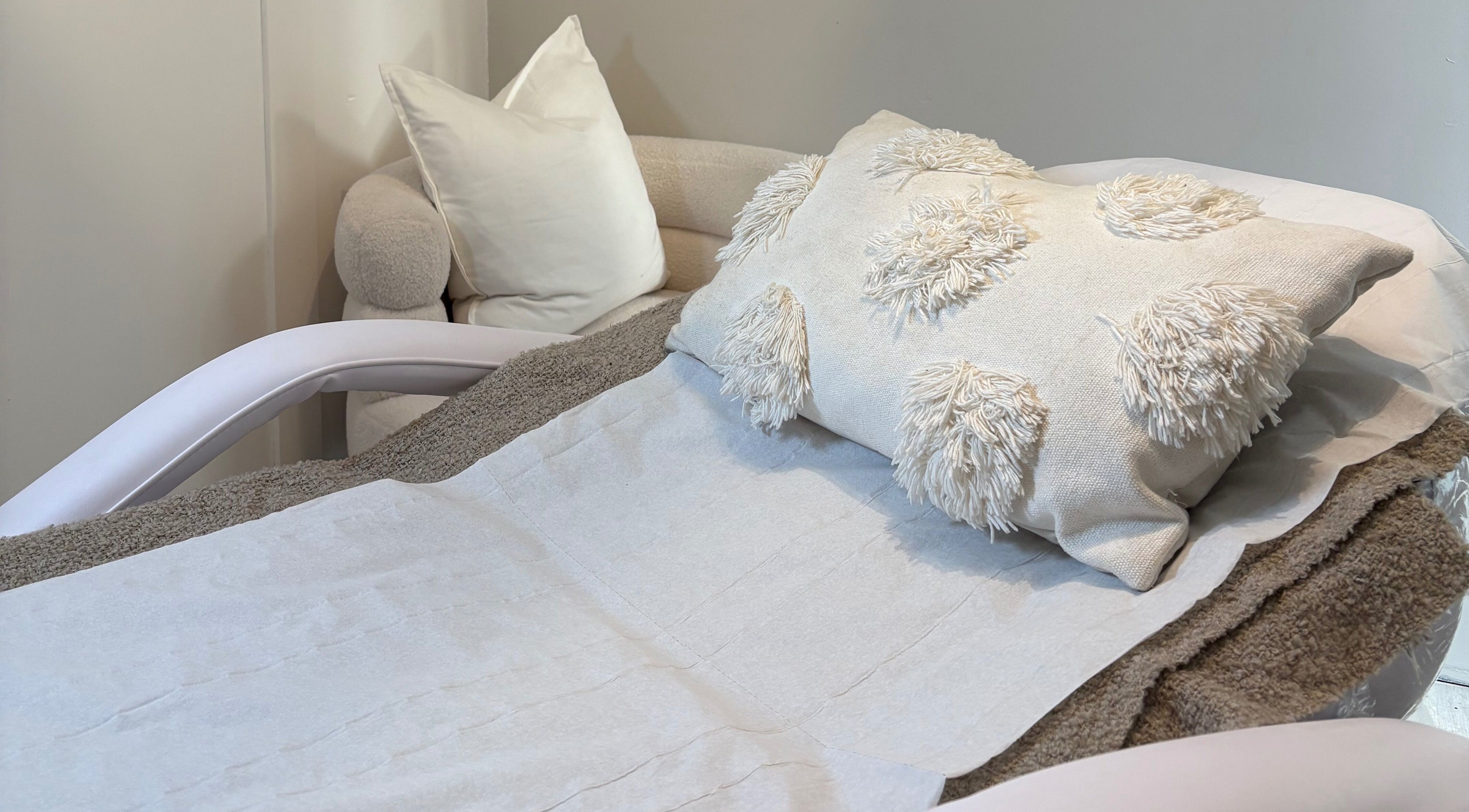 Relaxing treatment room at Mark One Beauty, Exeter, England, GB with plush pillows on a comfortable chair.