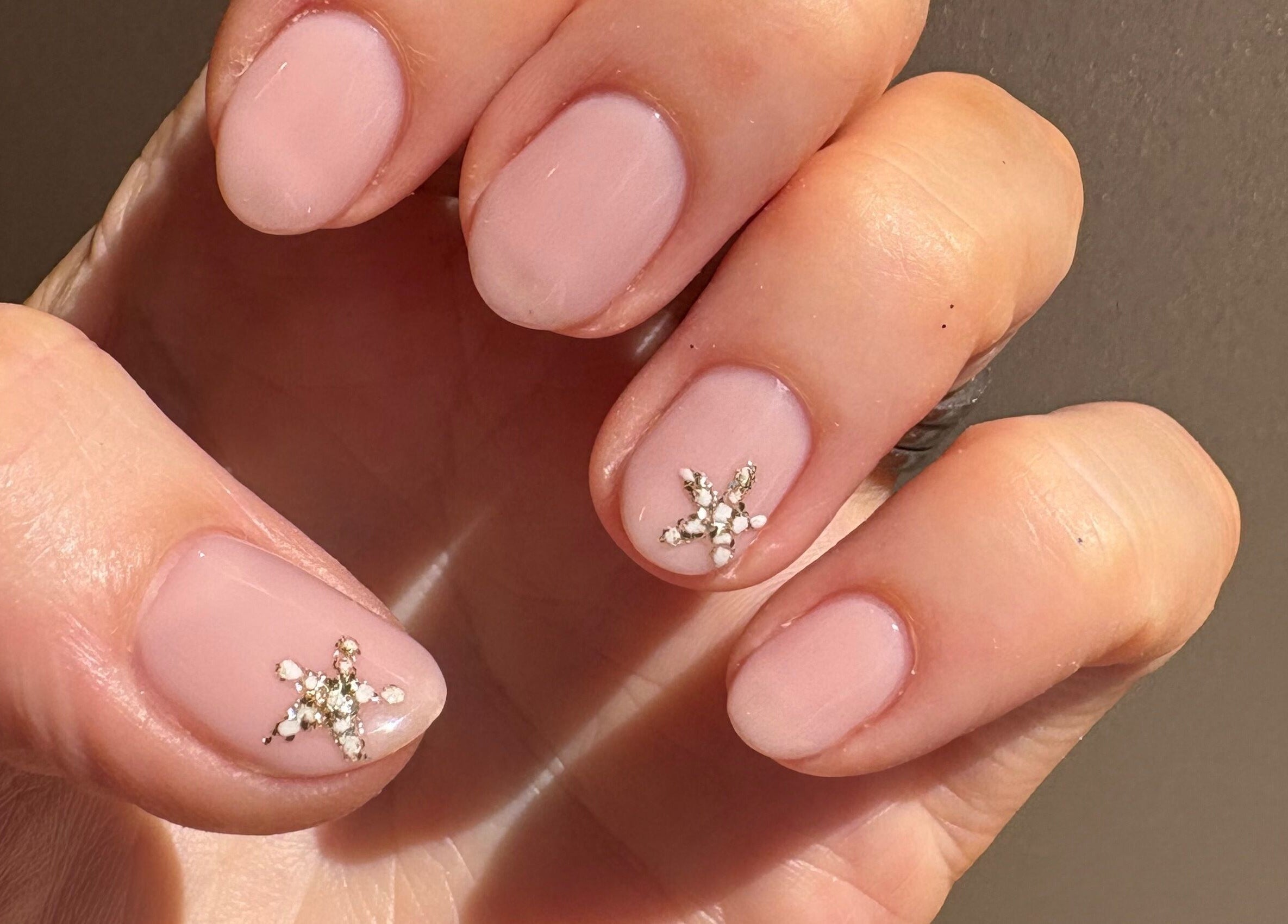 Close-up of delicate pink nails with sparkly accents at Mark One Beauty, Exeter, England, GB.