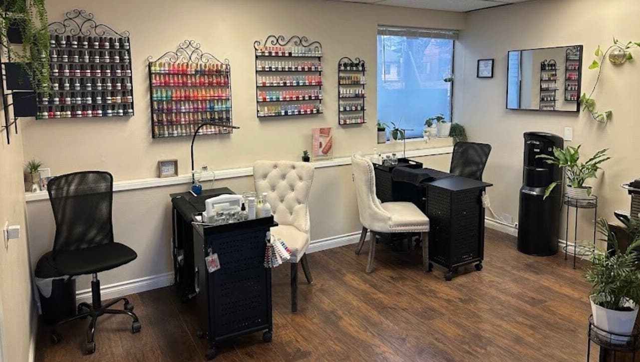 Stylish nail salon interior at Studio J, Sandpoint, Idaho, US, featuring chic seating and vibrant polish displays.