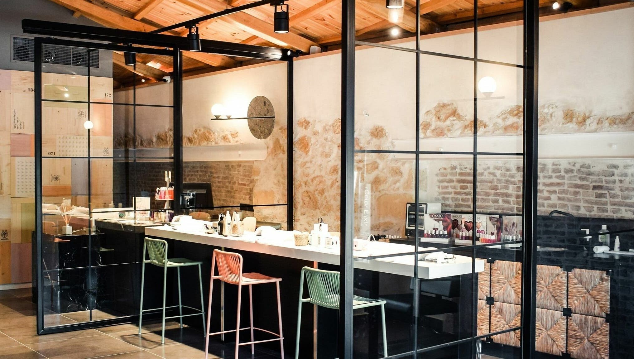 Σύγχρονος εσωτερικός χώρος του Apotheke Spa, Χανιά, GR με μαύρους πάγκους και καρέκλες μπαρ.