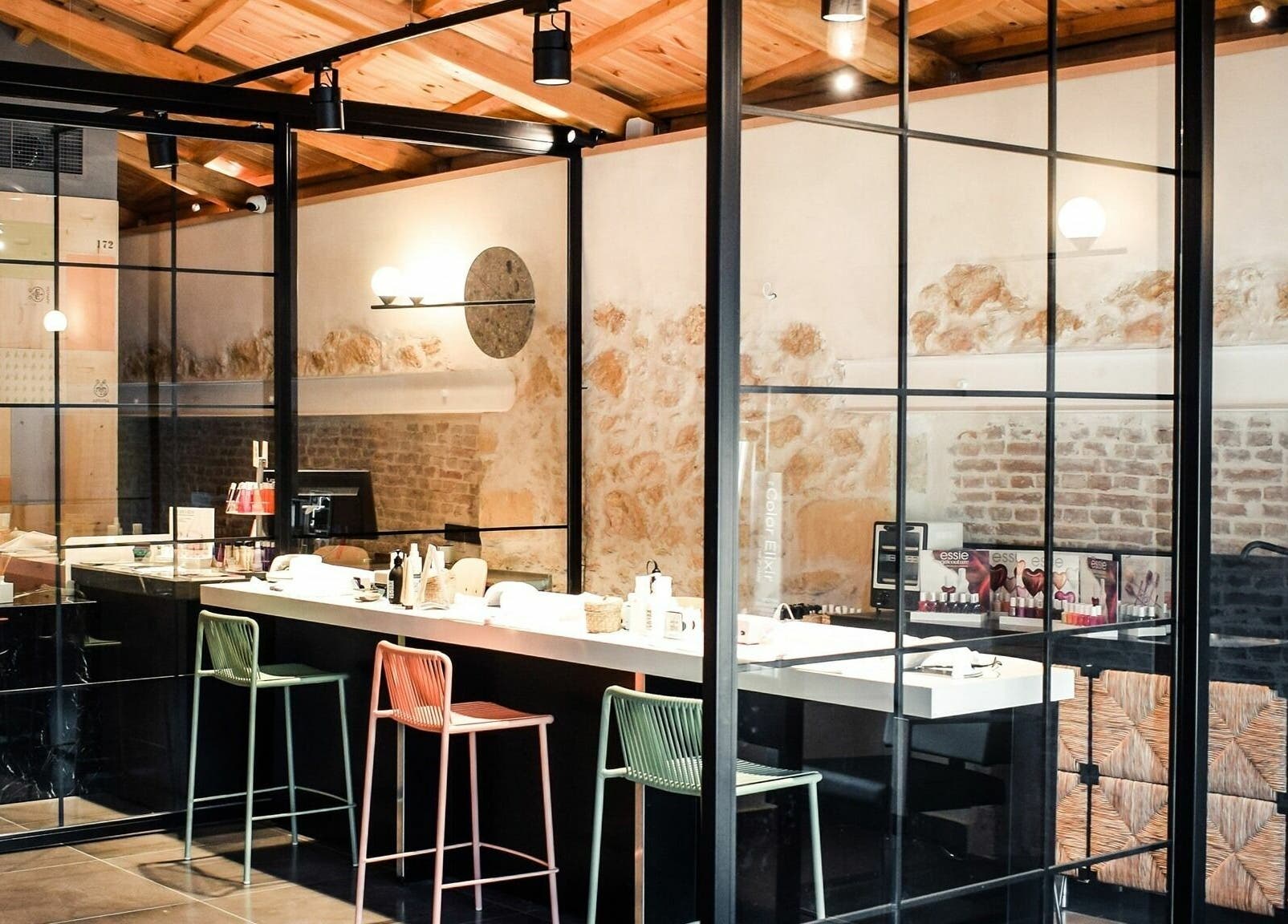 Σύγχρονος εσωτερικός χώρος του Apotheke Spa, Χανιά, GR με μαύρους πάγκους και καρέκλες μπαρ.