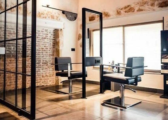 Κομψό σαλόνι στο Apotheke Spa, Χανιά, GR με μοντέρνα καθίσματα και διακόσμηση τοίχου.