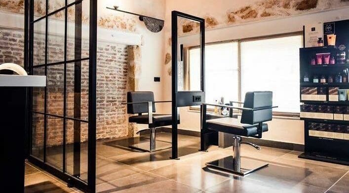 Κομψό σαλόνι στο Apotheke Spa, Χανιά, GR με μοντέρνα καθίσματα και διακόσμηση τοίχου.