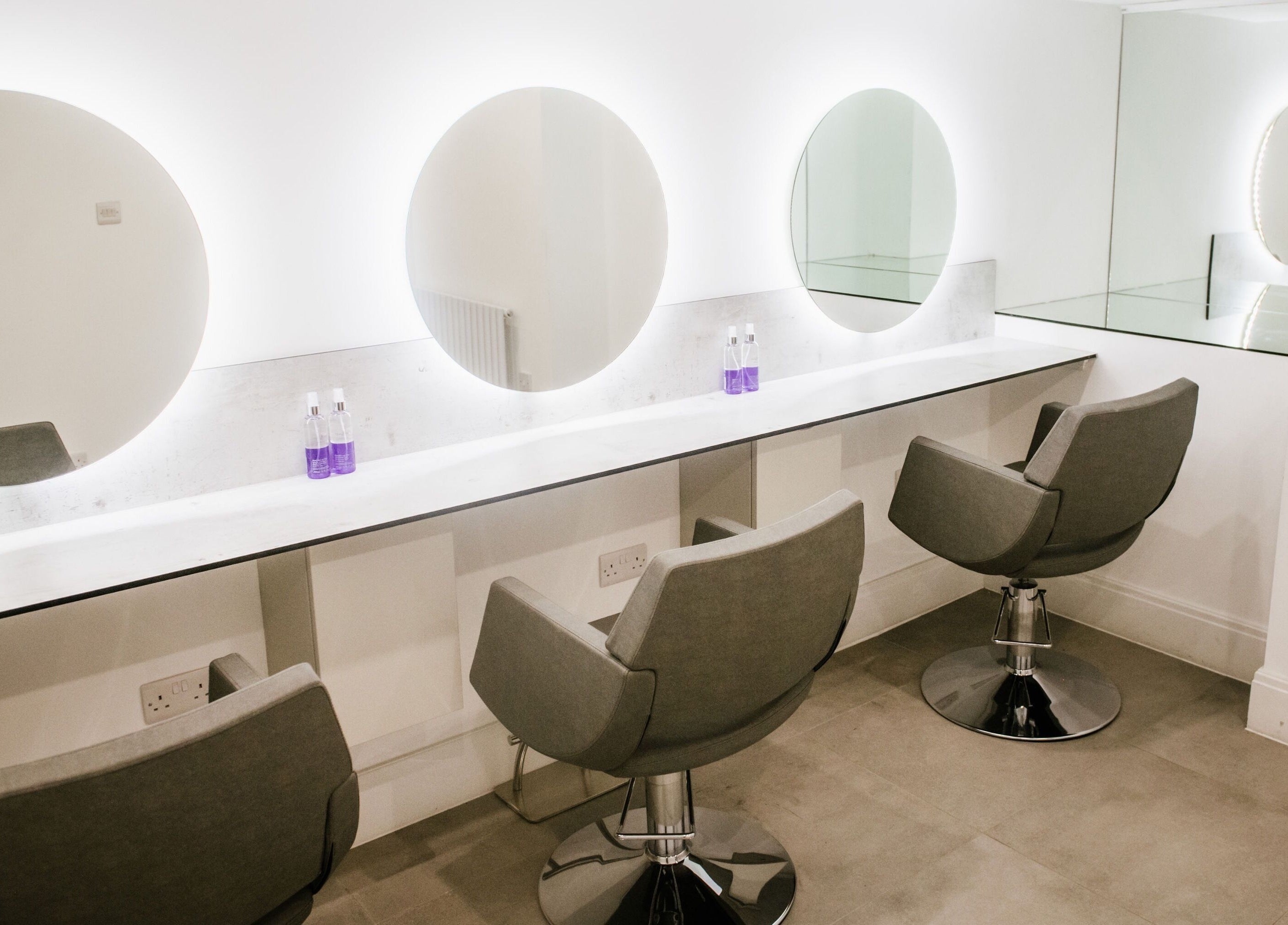 Modern salon interior at Opulence Hairdressing, Lytham Saint Annes, England, GB, featuring elegant mirrors and chairs.