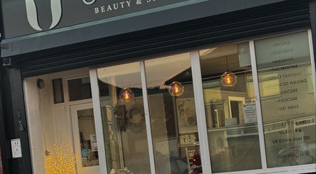 Front facade of Utopia Beauty and Skincare Belfast in Castlereagh, Northern Ireland, GB with glowing lights.
