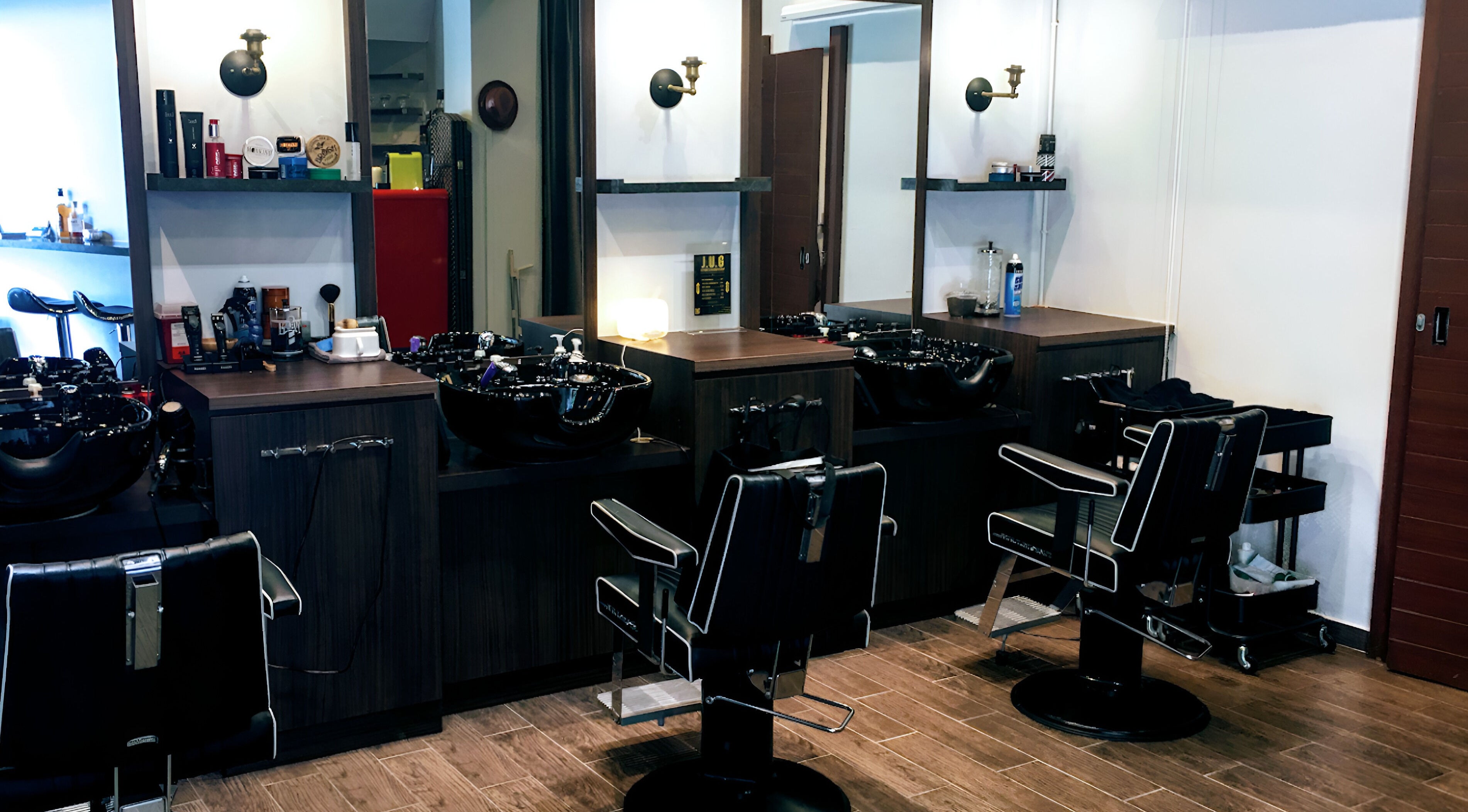 Interior of J.U.G Japanese Barbershop in Singapore, featuring stylish barber chairs and stations.