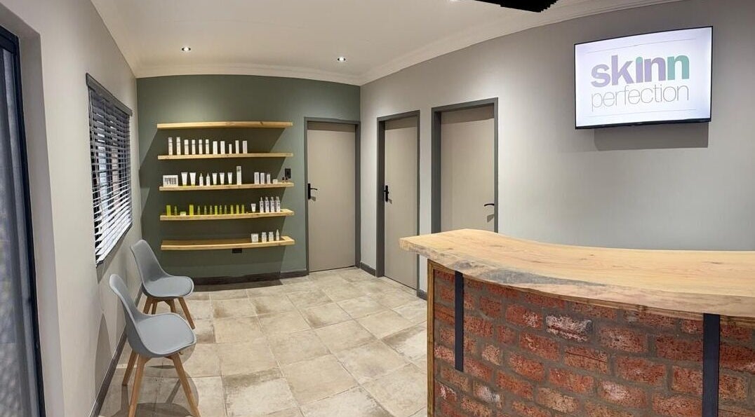 Modern reception area at Skinn Perfection in Tzaneen, Limpopo, ZA with stylish seating and product display.